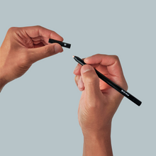 Load image into Gallery viewer, Stealth Fighter Concealer Pen for men opened and held by two hands. One hand holding the pen cap, and another hand holding the pen.
